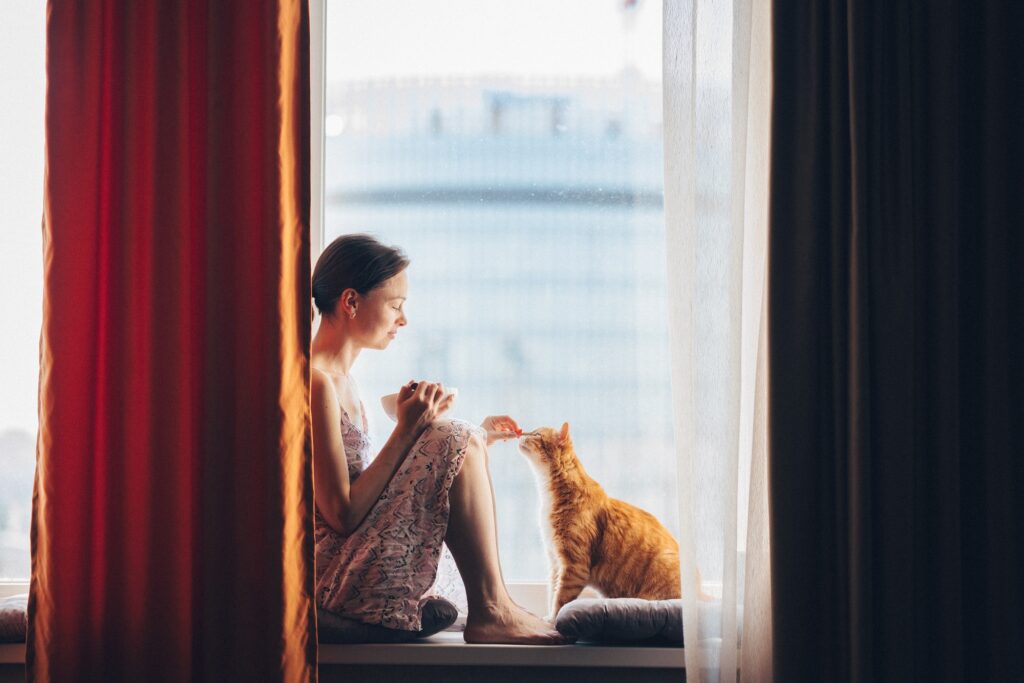 Young girl with a red cat at home